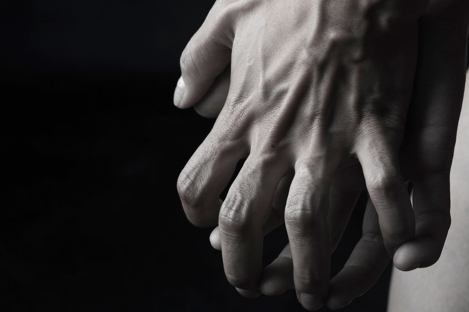 Close-up of an adult child's hand resting on an older parent's hand, representing family caring and the Carer's Support Grant in Ireland